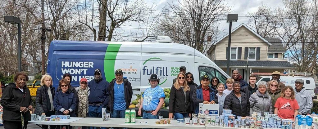 Volunteers at a Fulfill food distribution, beside the Fulfill truck