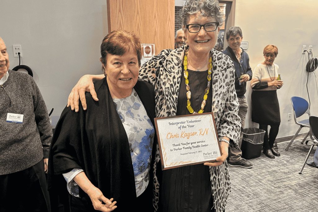 A volunteer holding her Interpreter Volunteer of the Year certificate