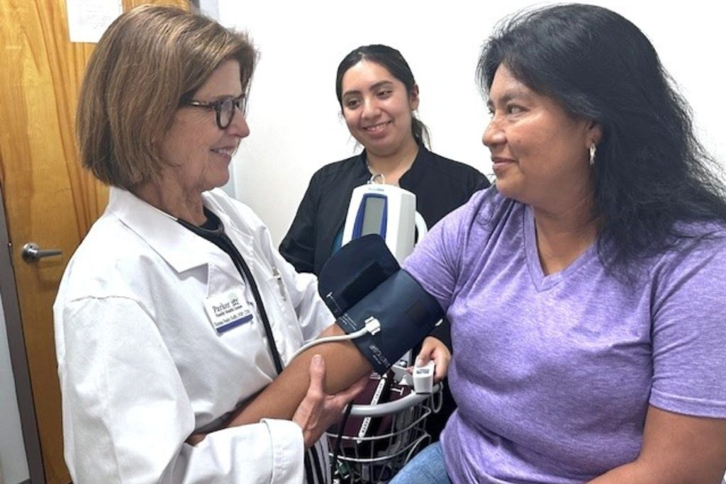 A volunteer physician taking a patient's blood pressure