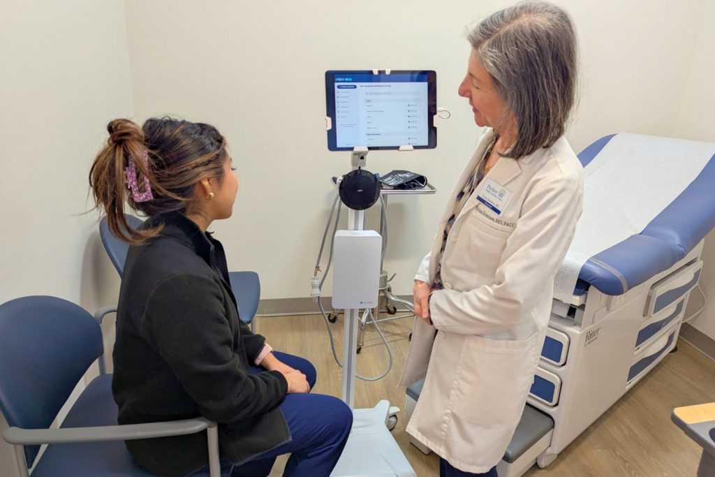 A clinician talking with a patient in an exam room