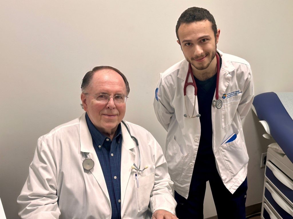 A volunteer physician and a medical student in an exam room
