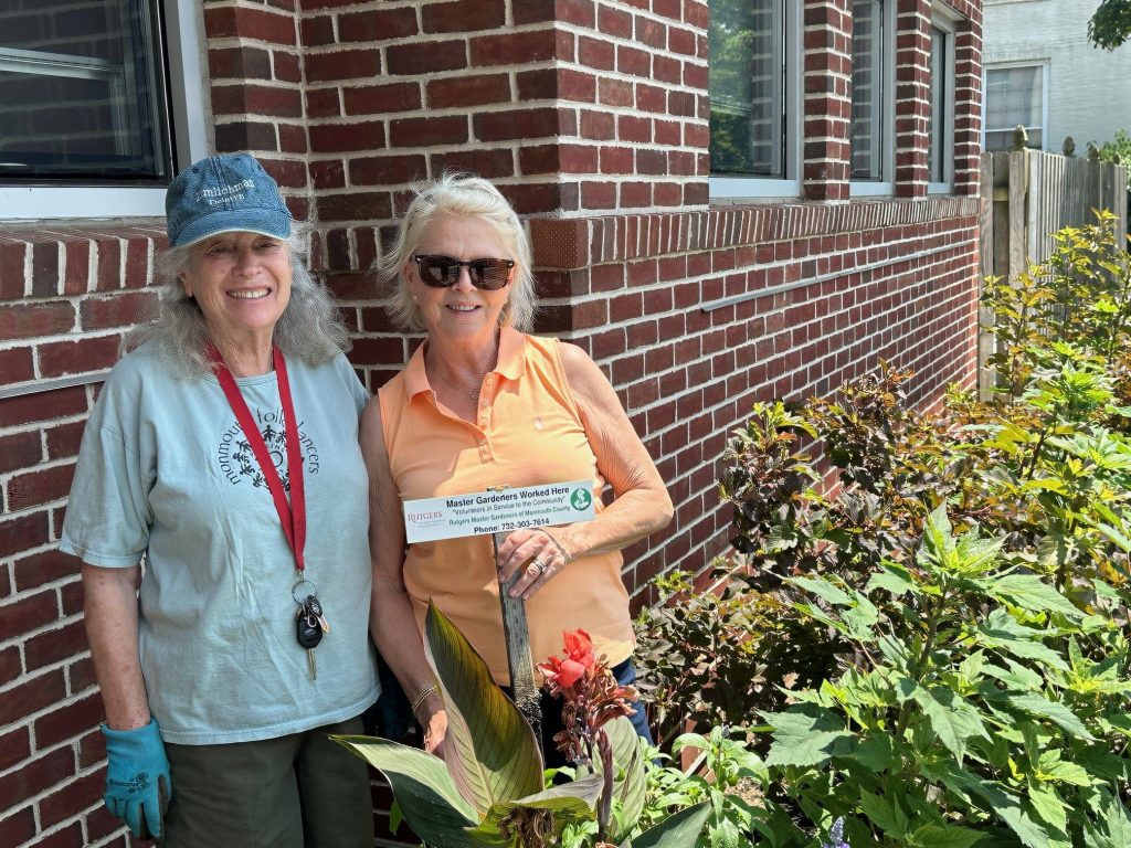 Maya and Gloria, master gardener volunteers, in the garden beside the clinic